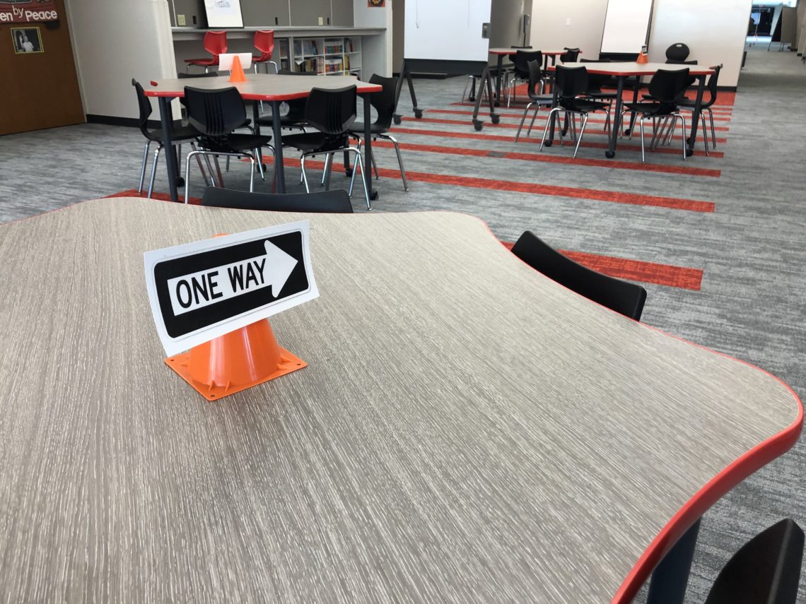 photo of a table with a one way sign and traffic cone