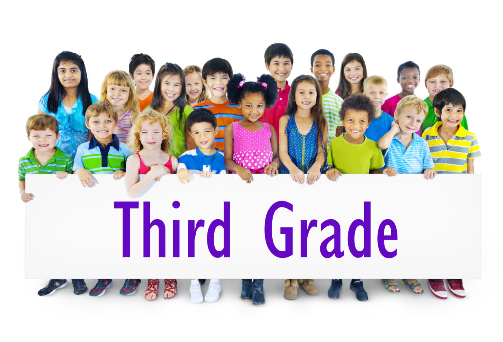 kids holding a third grade poster