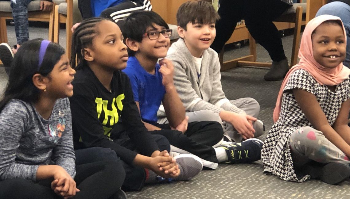 group of elementary students sitting on the floor