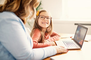 child and mother working on a laptop computer