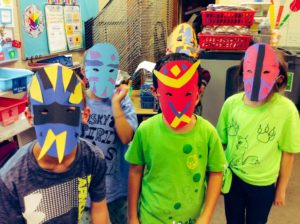 students wearing colorful masks they created
