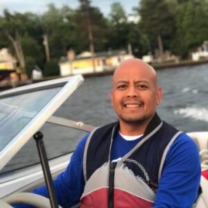 photo of Principal Mitch Balingit driving a boat
