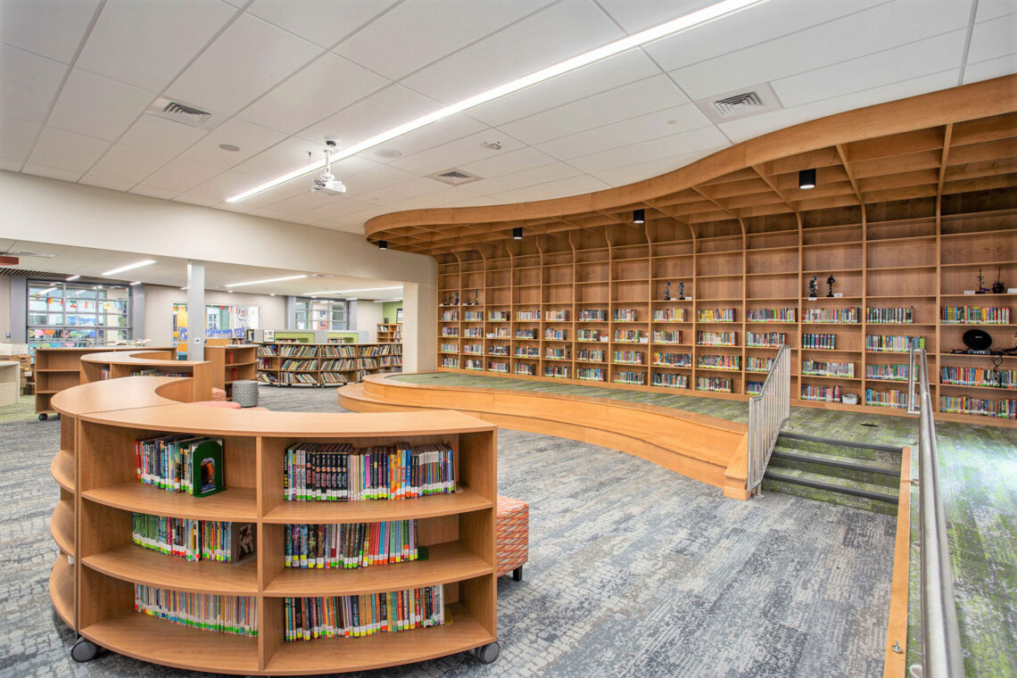 an elementary school library with books, book shelves and new carpet and lighting