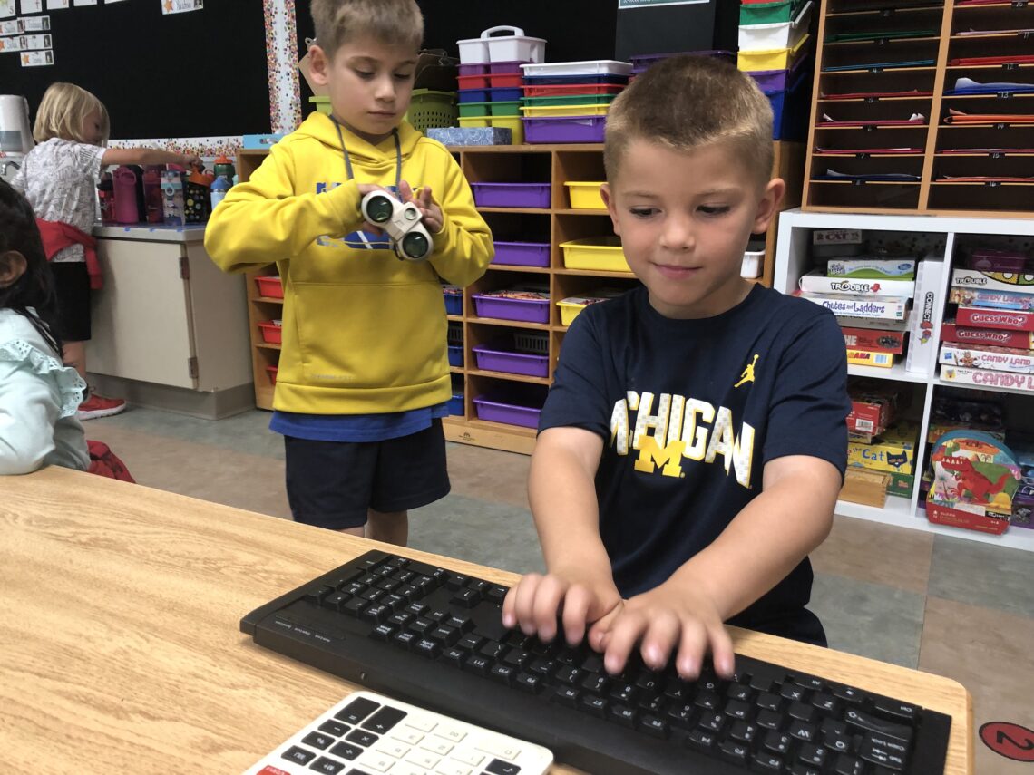 two elementary boys and one typing on a keyboard