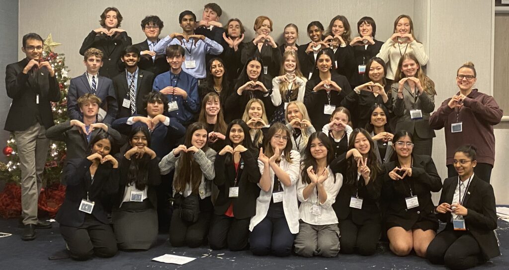 Model UN Students posing for pic making a heart shape with thier hands
