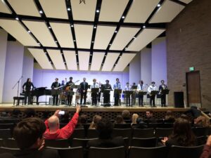 a high school jazz ensemble stand to take a bow after their performance