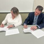 FHPS School Board President, Kristen Fauson and Superintendent Candidate Ben Kirby signing a contract.