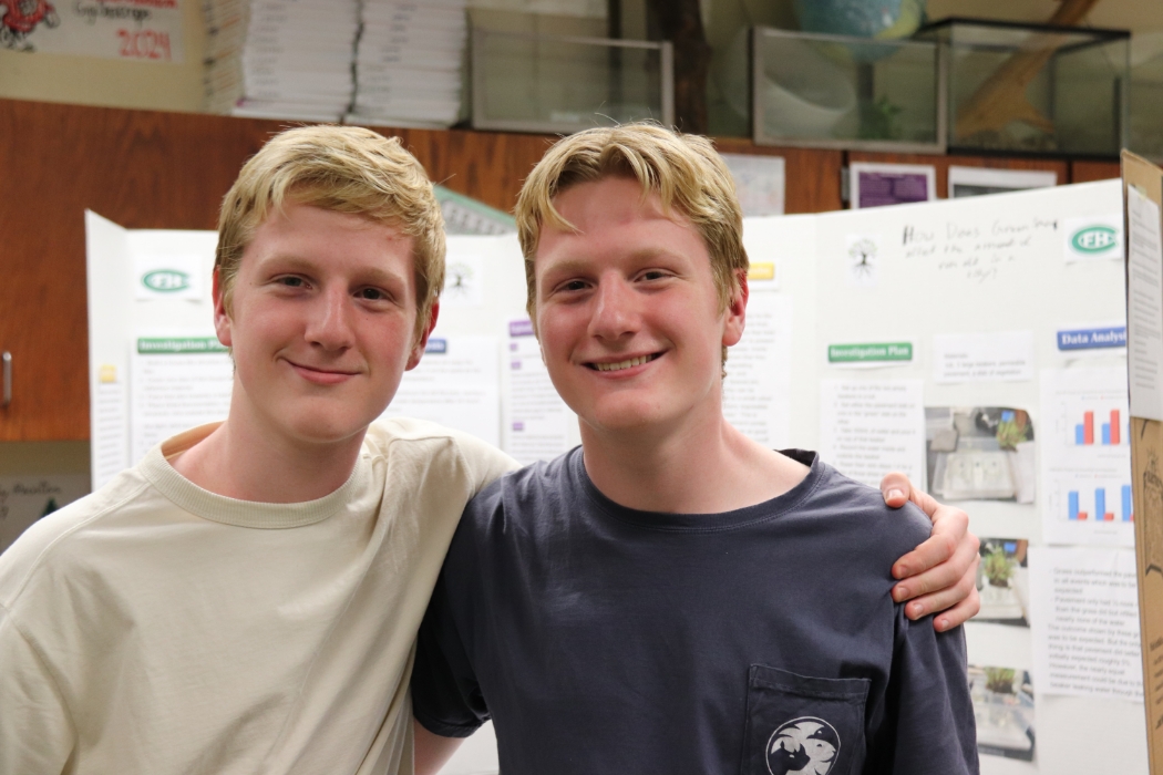 two male students posing in front of their presentation