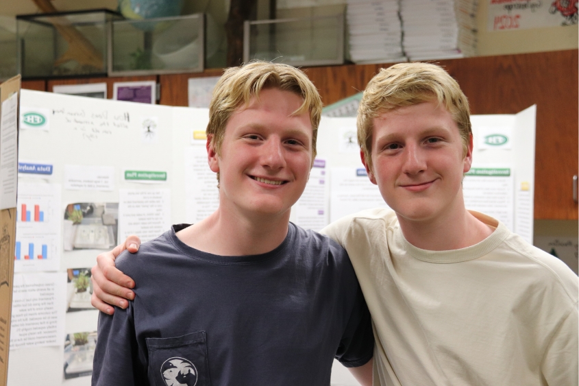 two male students posing in front of their presentation