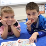 two young students in class posing for picture