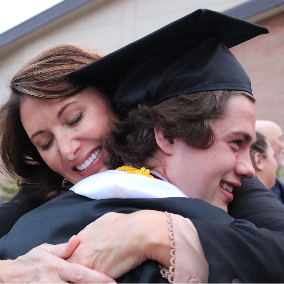 student hugging a mother at graduation