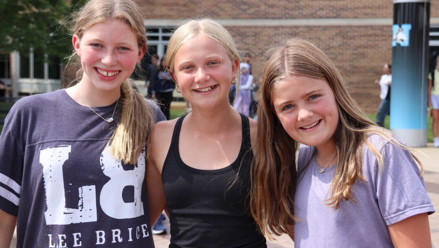 three female students posing for a picture outside