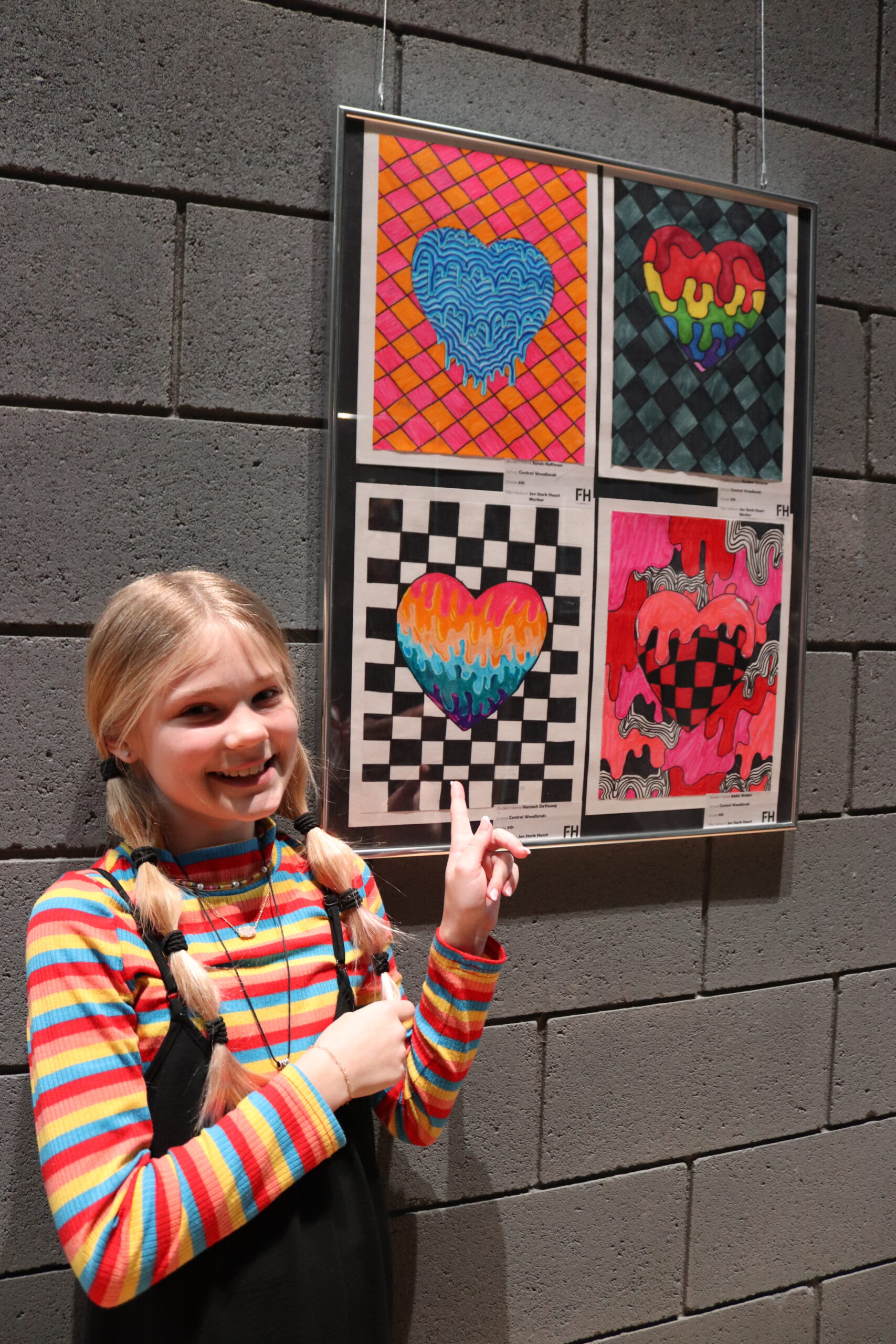 a student showing off her art in a gallery