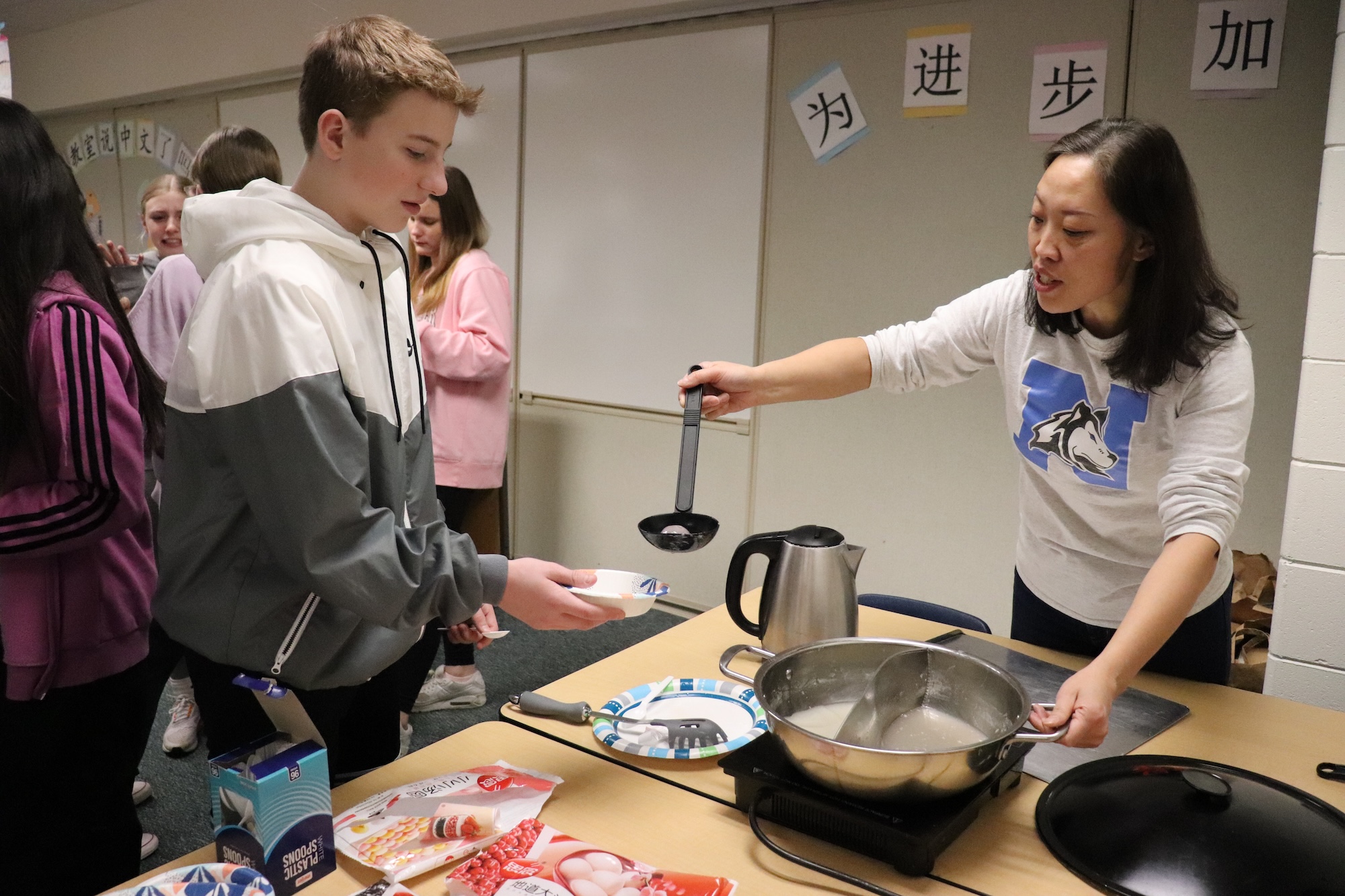 teacher giving a student some food in a foreign language class