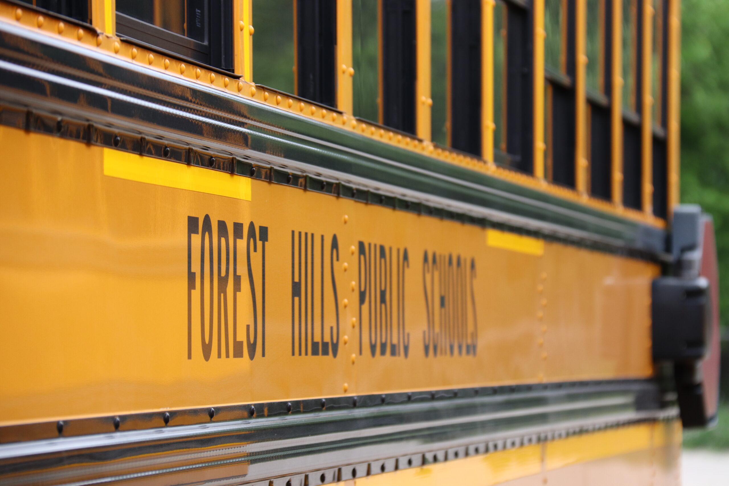 side of school bus showing Forest Hills public school text