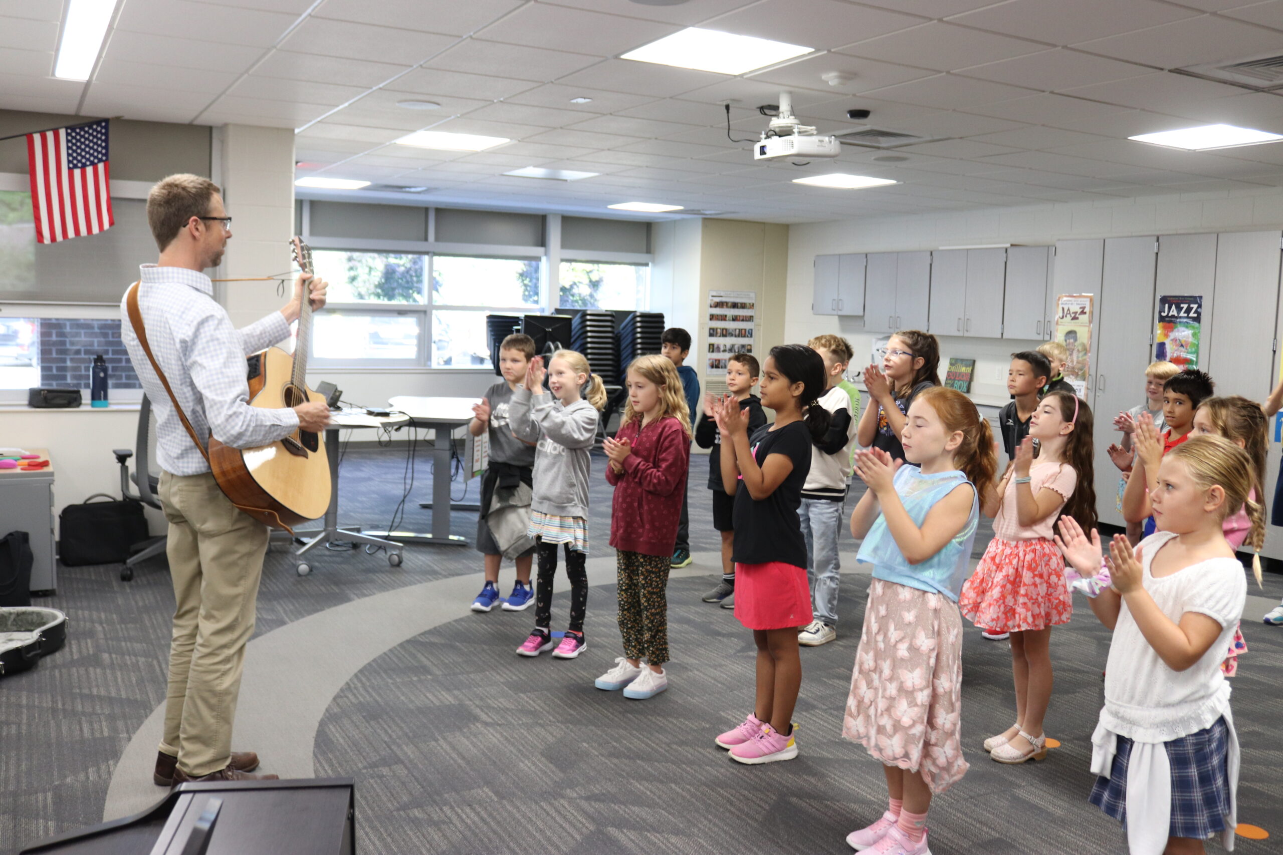 teacher with a guitar teaching kids how to sing along