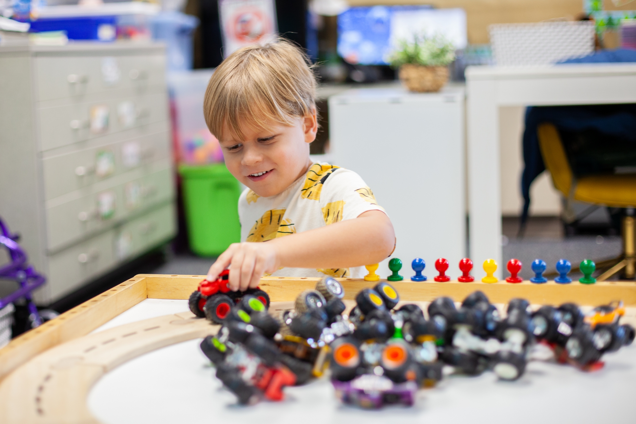 young boy playing monster truck on track