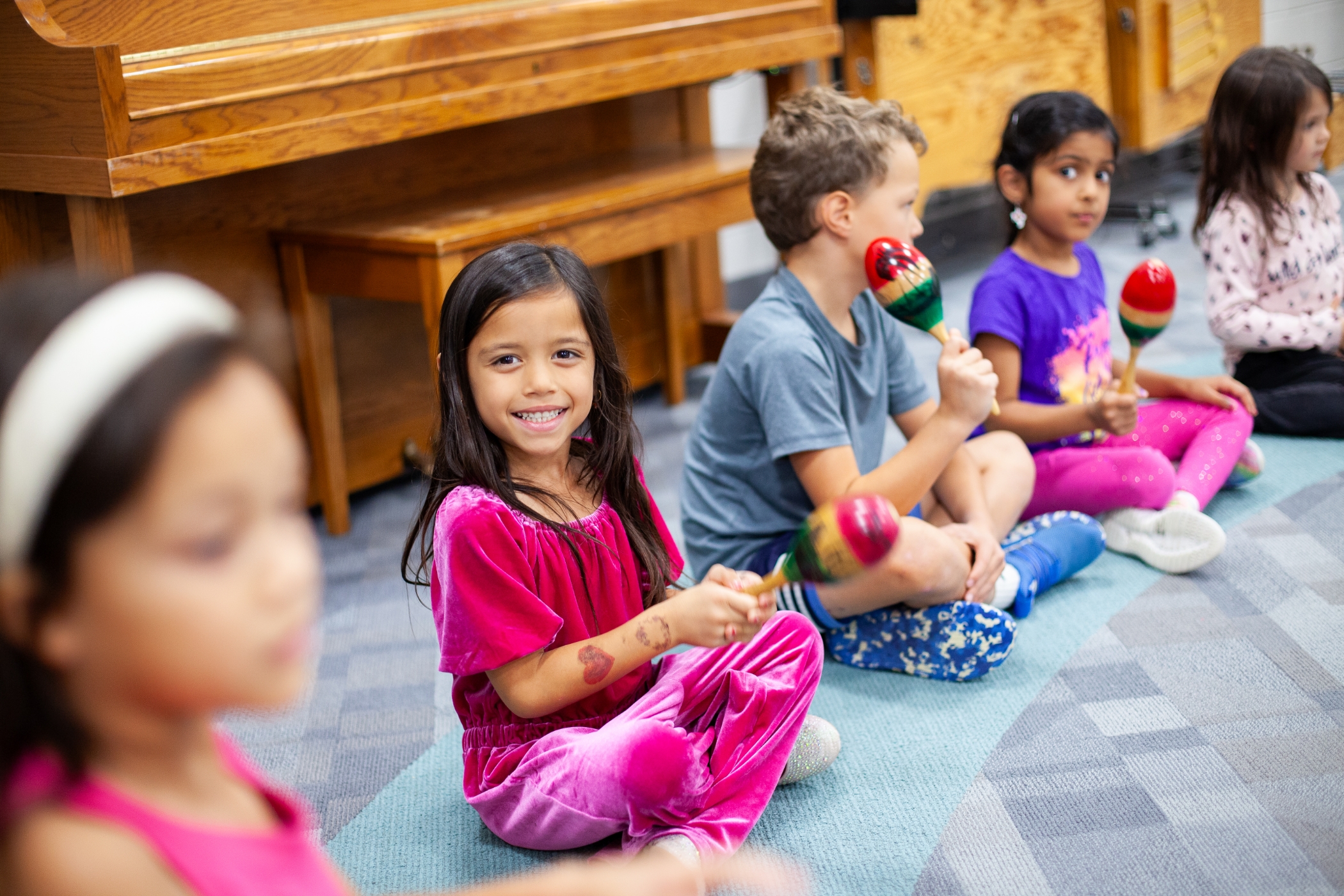 young students sitting in a circle playing the maraca