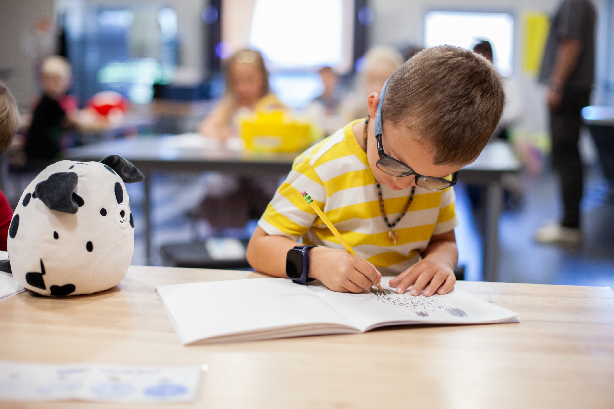 young boy drawing at a desk