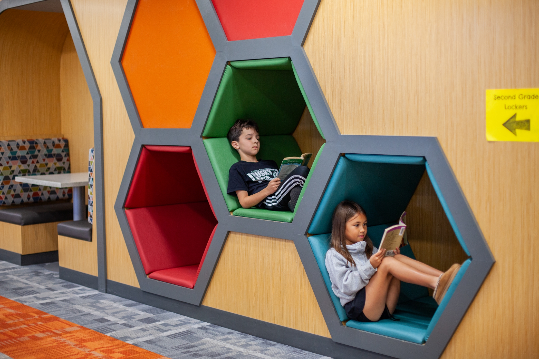 students sitting in fun hexagon cubbies and reading