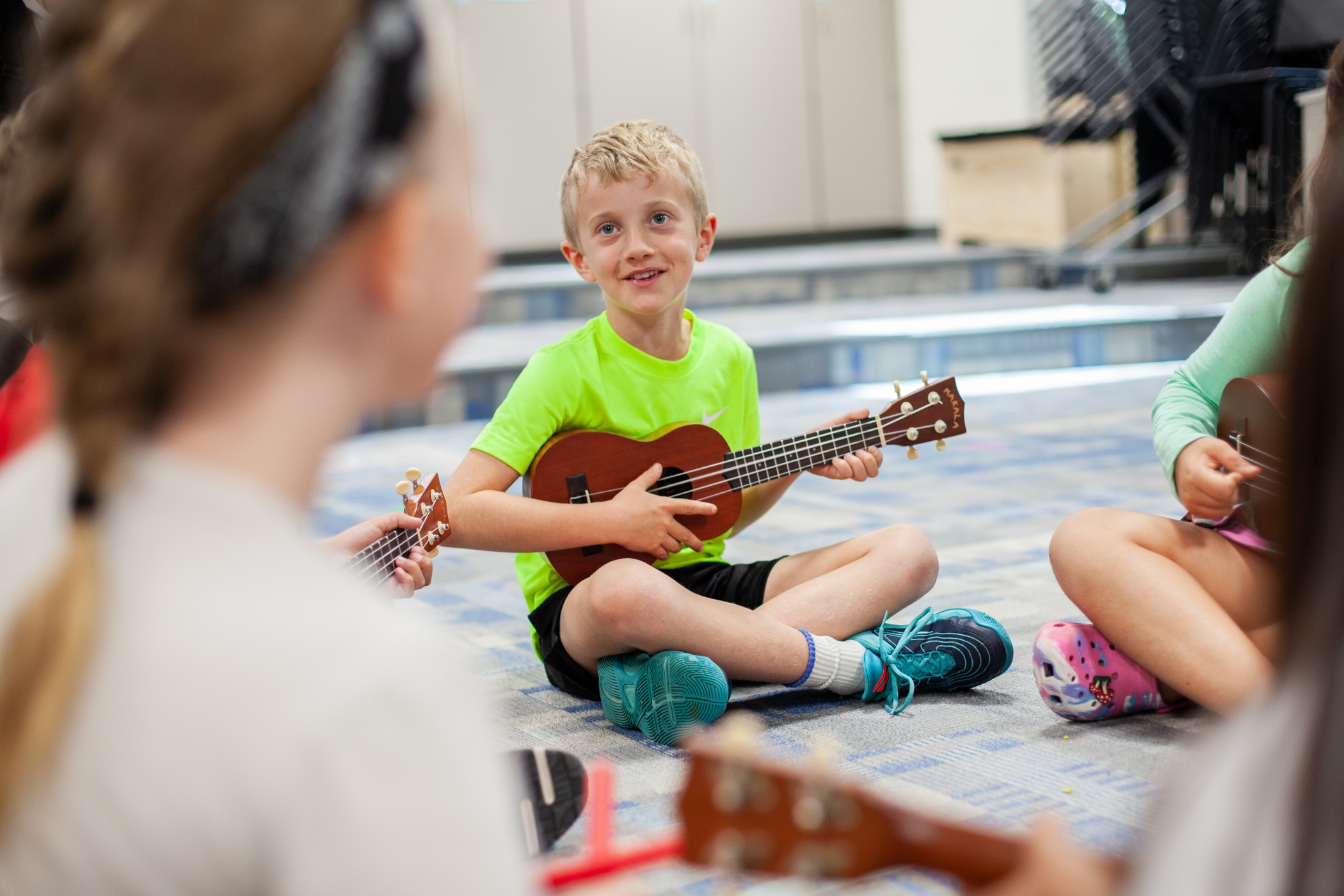 students playing the ukelele in a circle