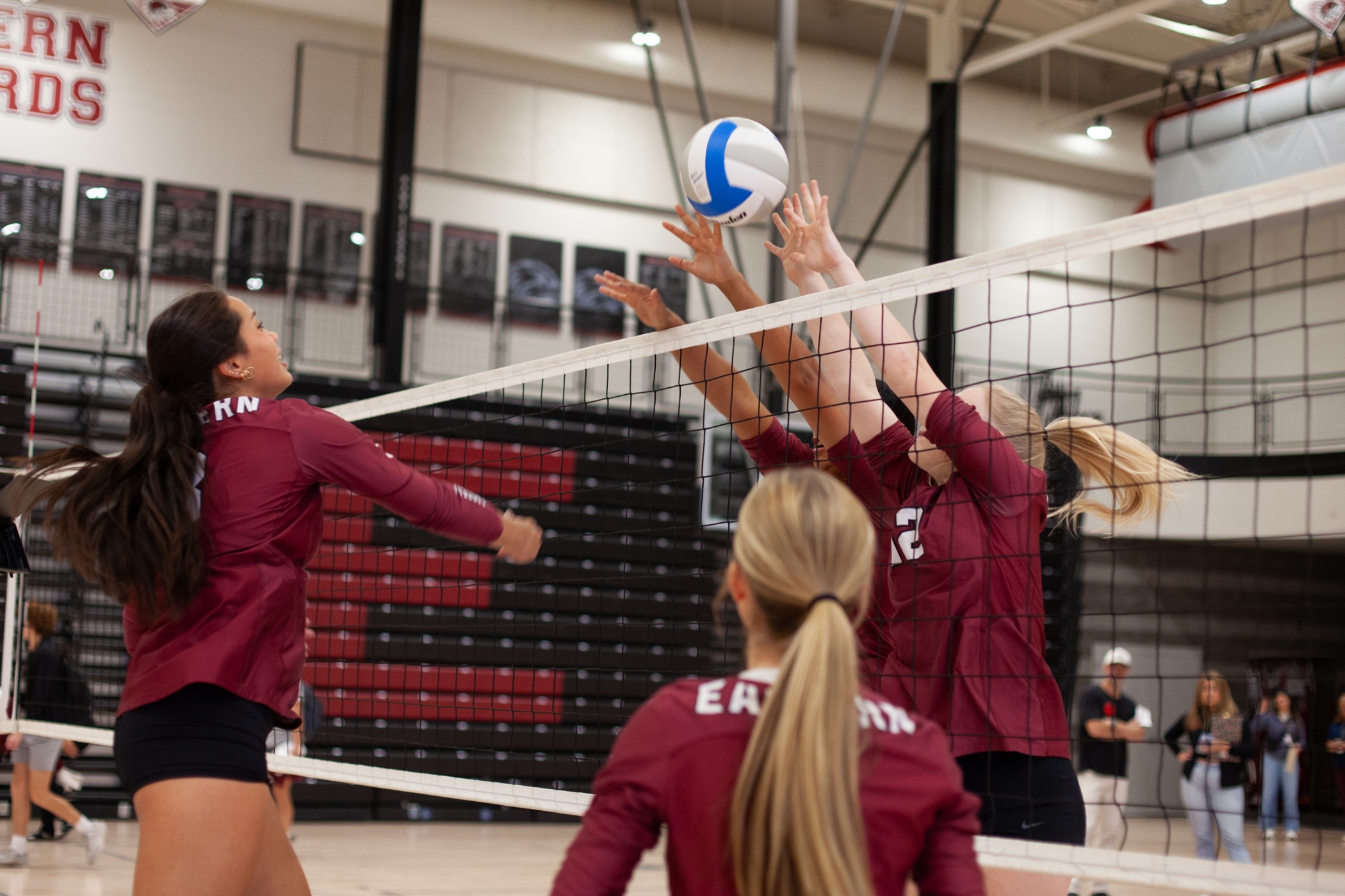 volleyball players blocking a spike