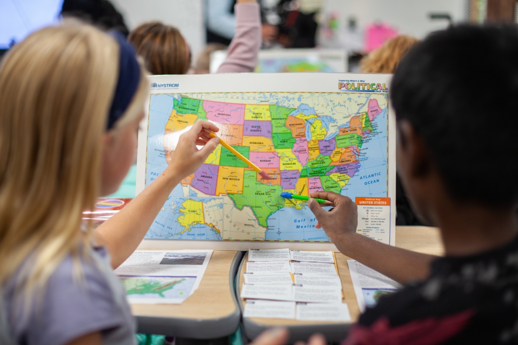 students learning geography with map of the USA