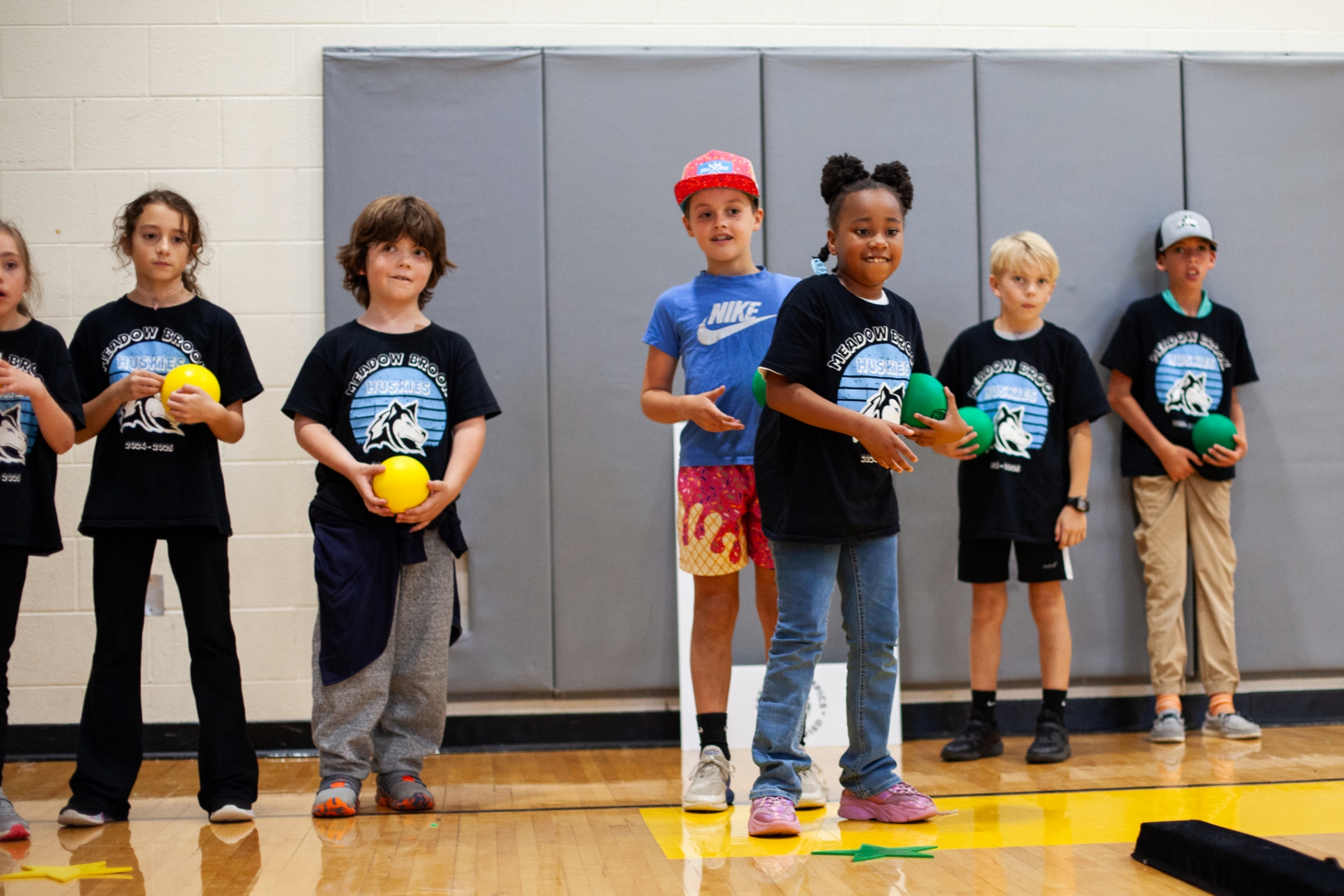students in a gym playing a game with balls