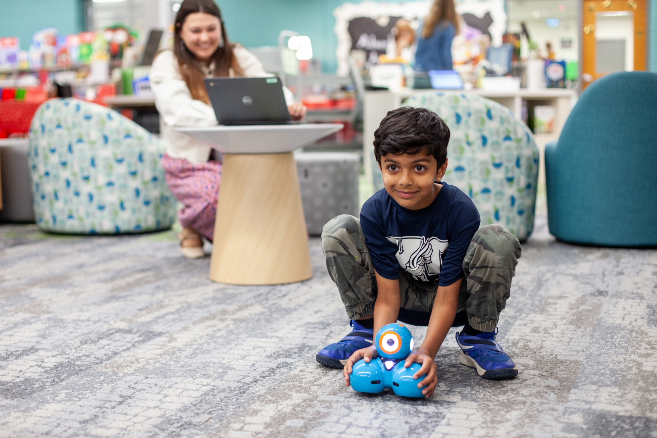 young student playing with a robot