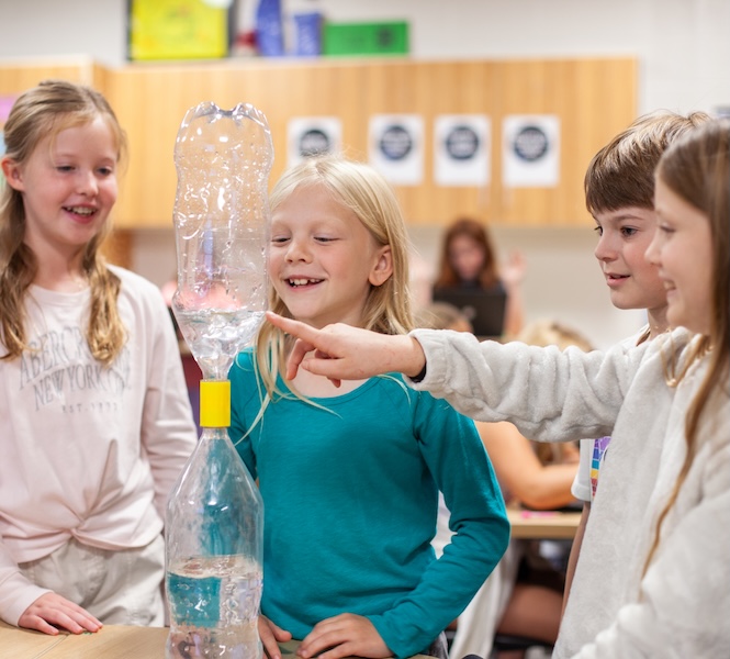 four students working on a waterbottle science project