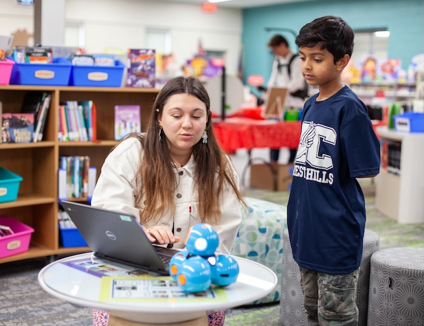 teacher showing student something on a computer