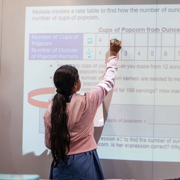 student working on fractions on a whiteboard