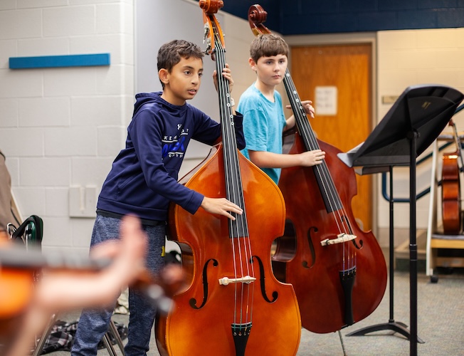 two students playing cellos