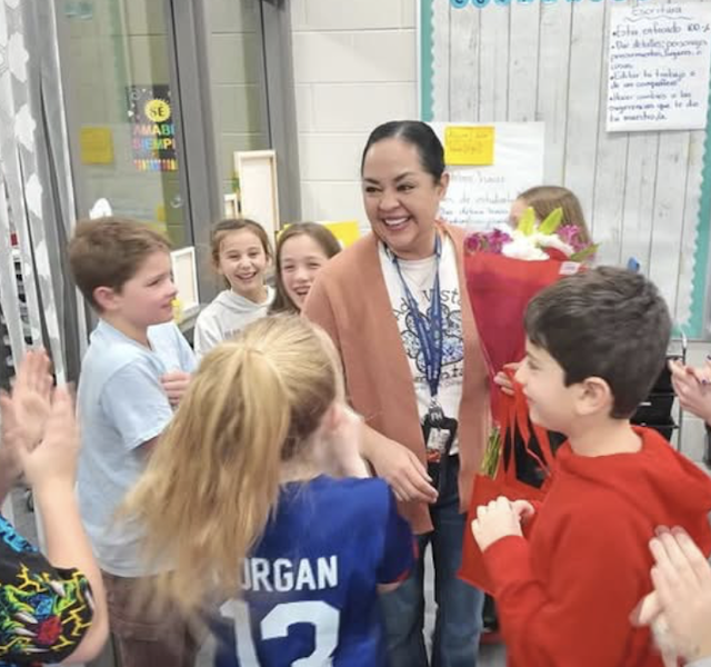 young students gathered around a teacher in Spanish immersion class