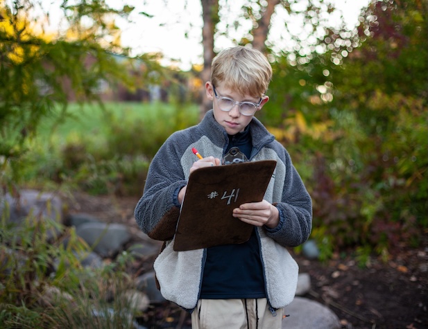 student with clipboard in the outdoors