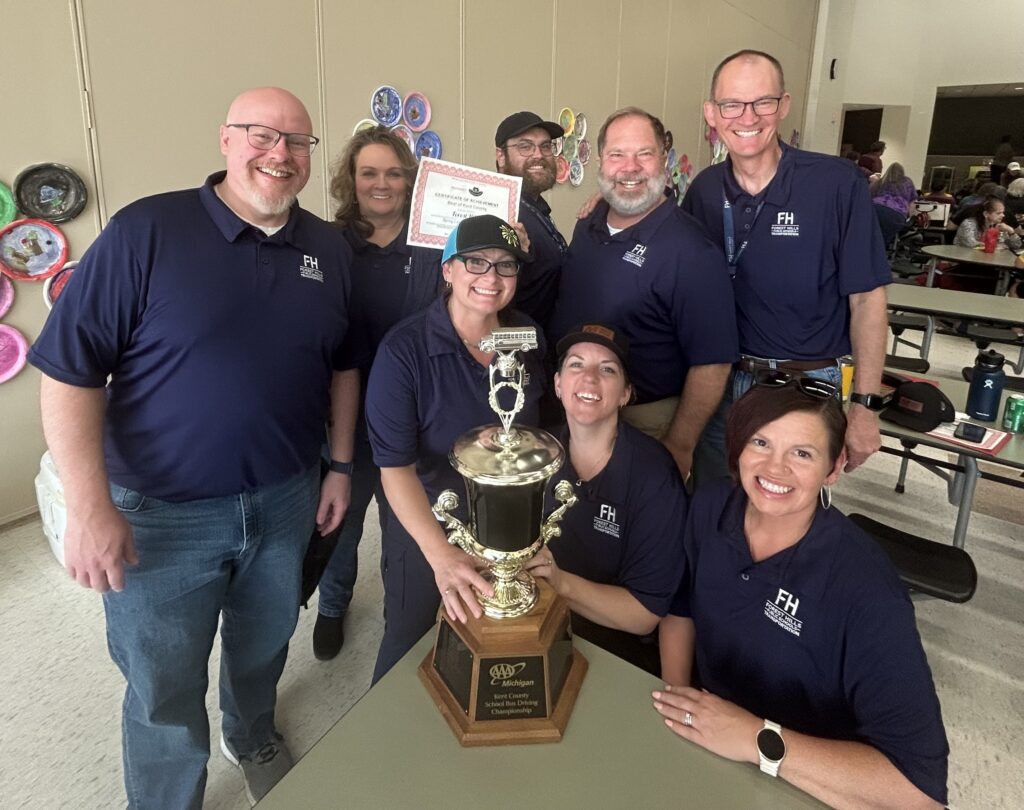 eight adults hold up a trophy