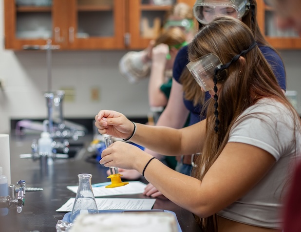 2 students doing a science experiment in a lab
