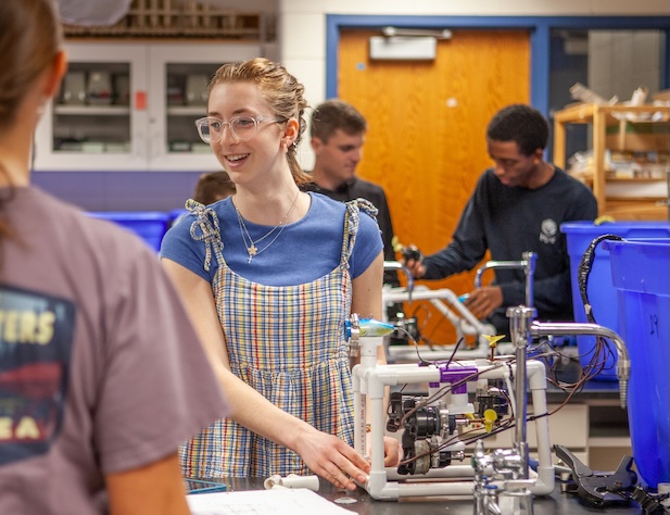 student smiling while working with technical project