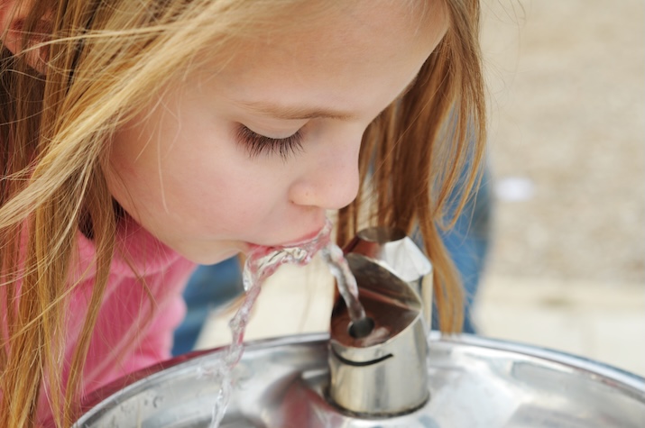 girl drinking water from a drinking fountain