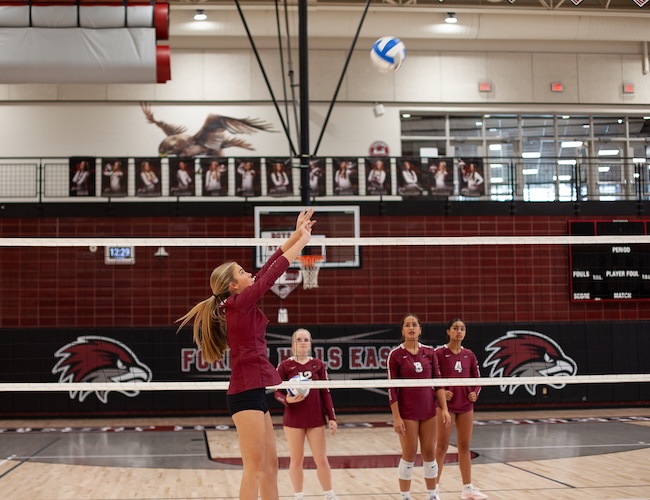 volleyball player setting the ball in a gym