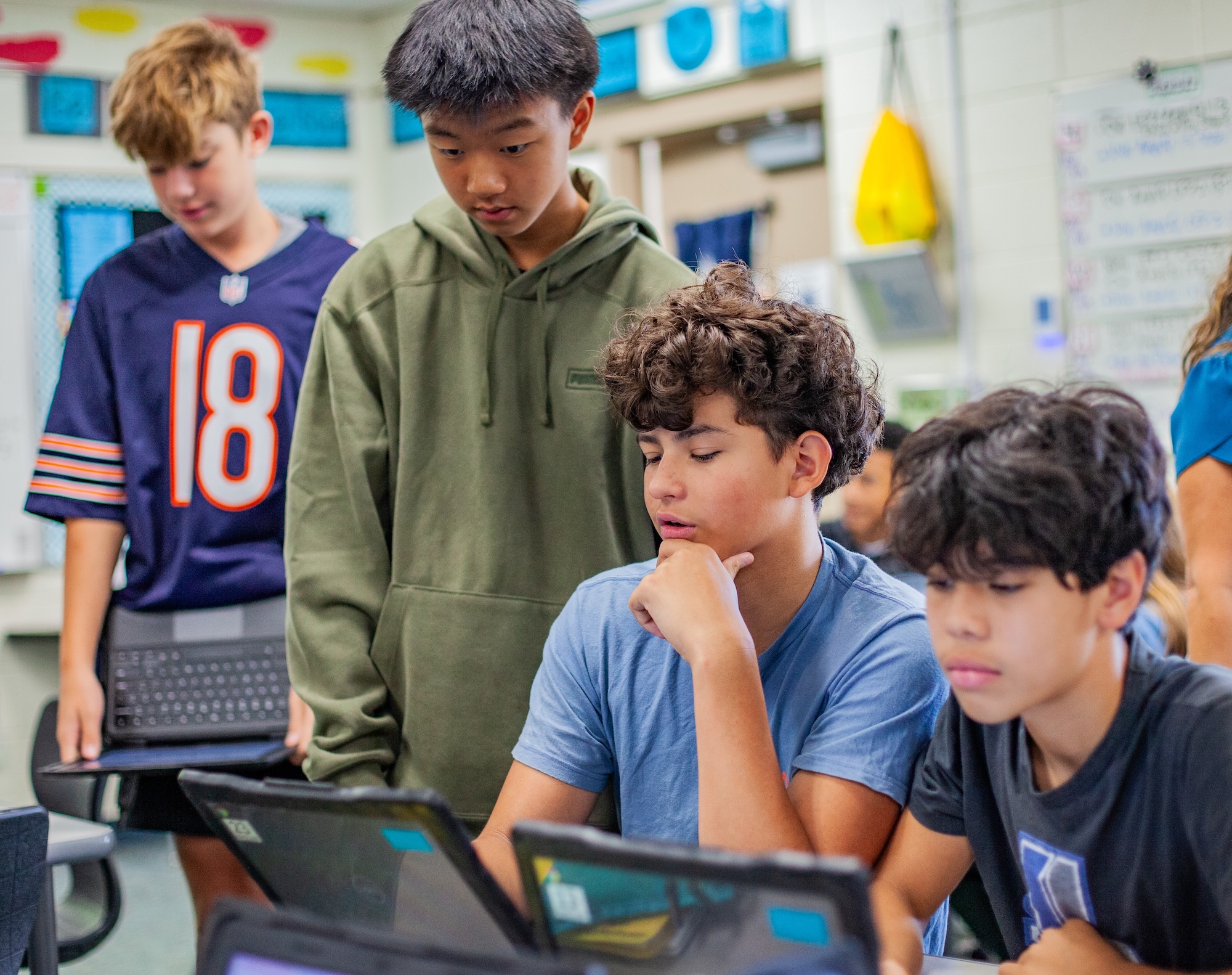 male students grouped around laptops