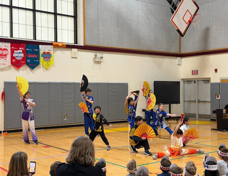 students performing in a gym for mandarin immersion class