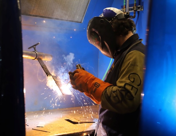 student welding something with a welding mask on