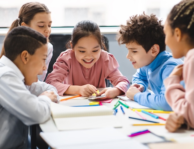 A group of young students learning together at a desk