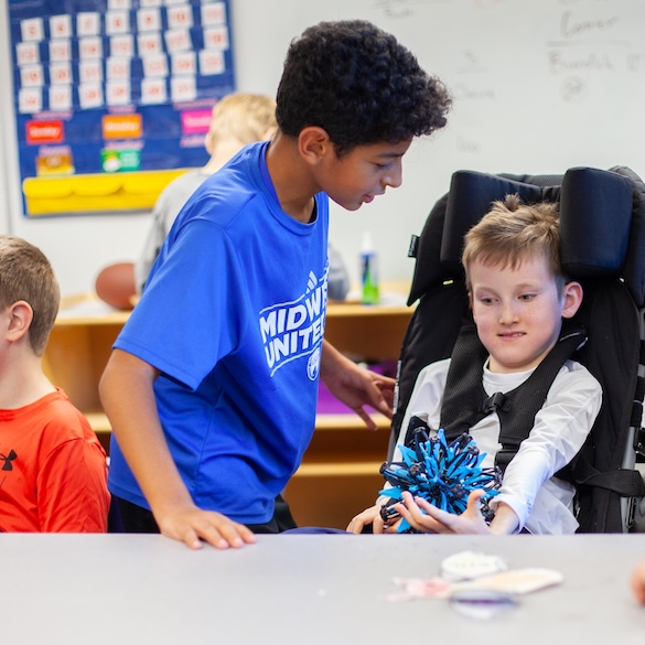 two students interacting with Hoberman sphere