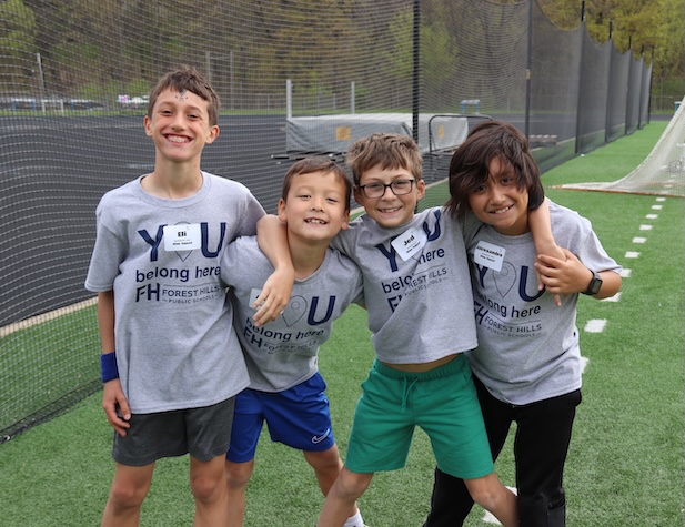 Four elementary students posing for a picture at a field