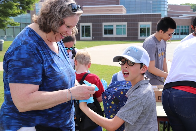 teacher helping student put on a glove