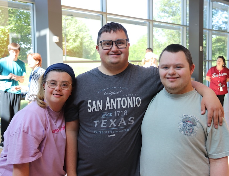 two male students and one female student smiling for a picture