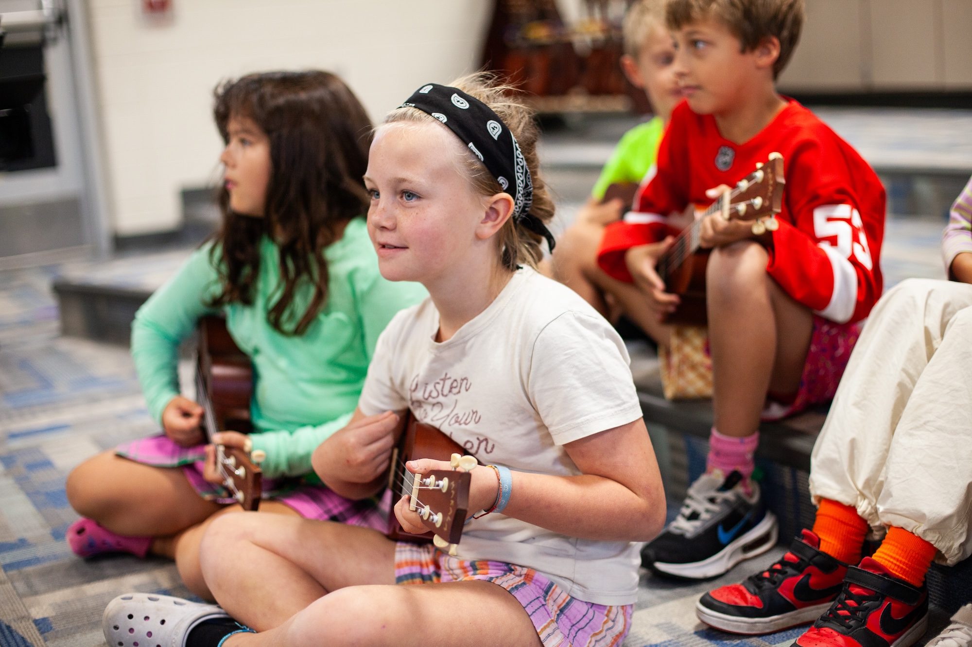 young students learning how to play the guitar in class