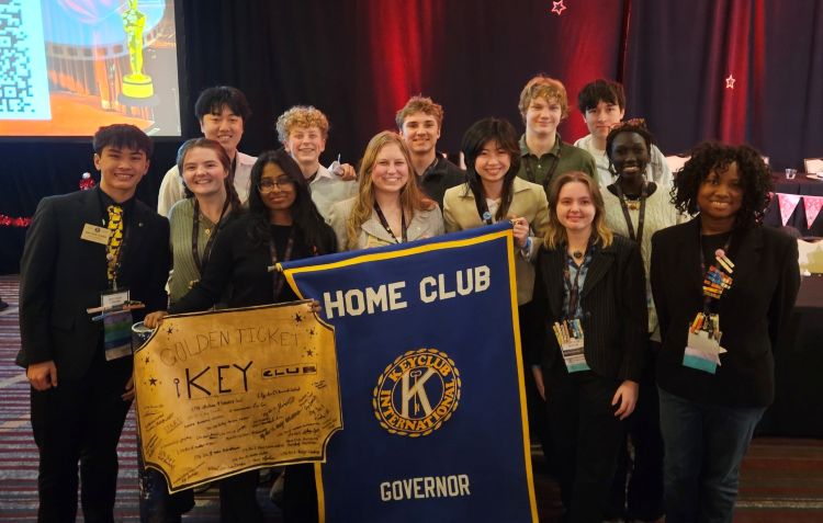 Key club group picture holding up a banner for governor of the home club